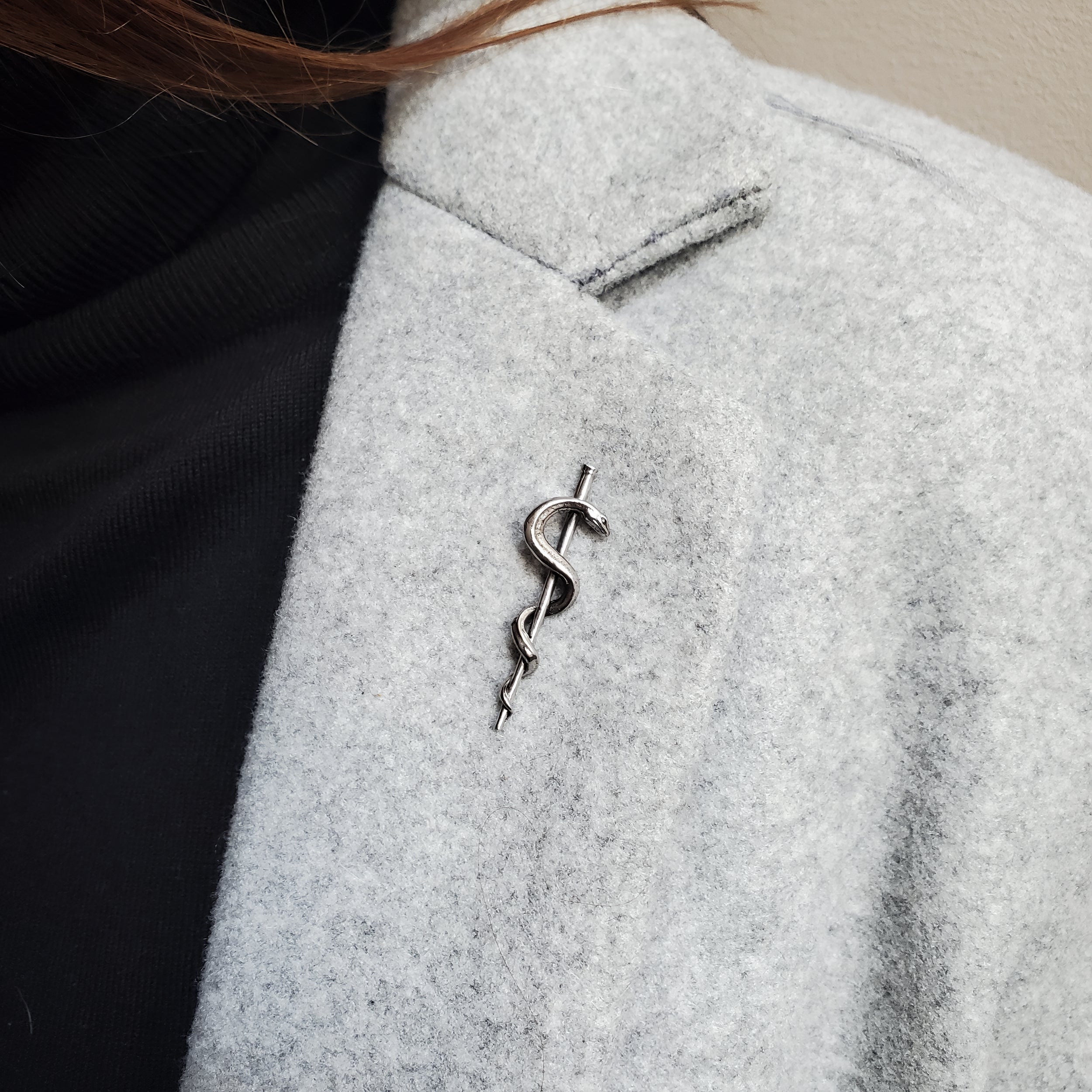 Snake coiled on stick, showing scales and texture | Moon Raven