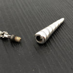 Metallic cylindrical object on a textured black surface