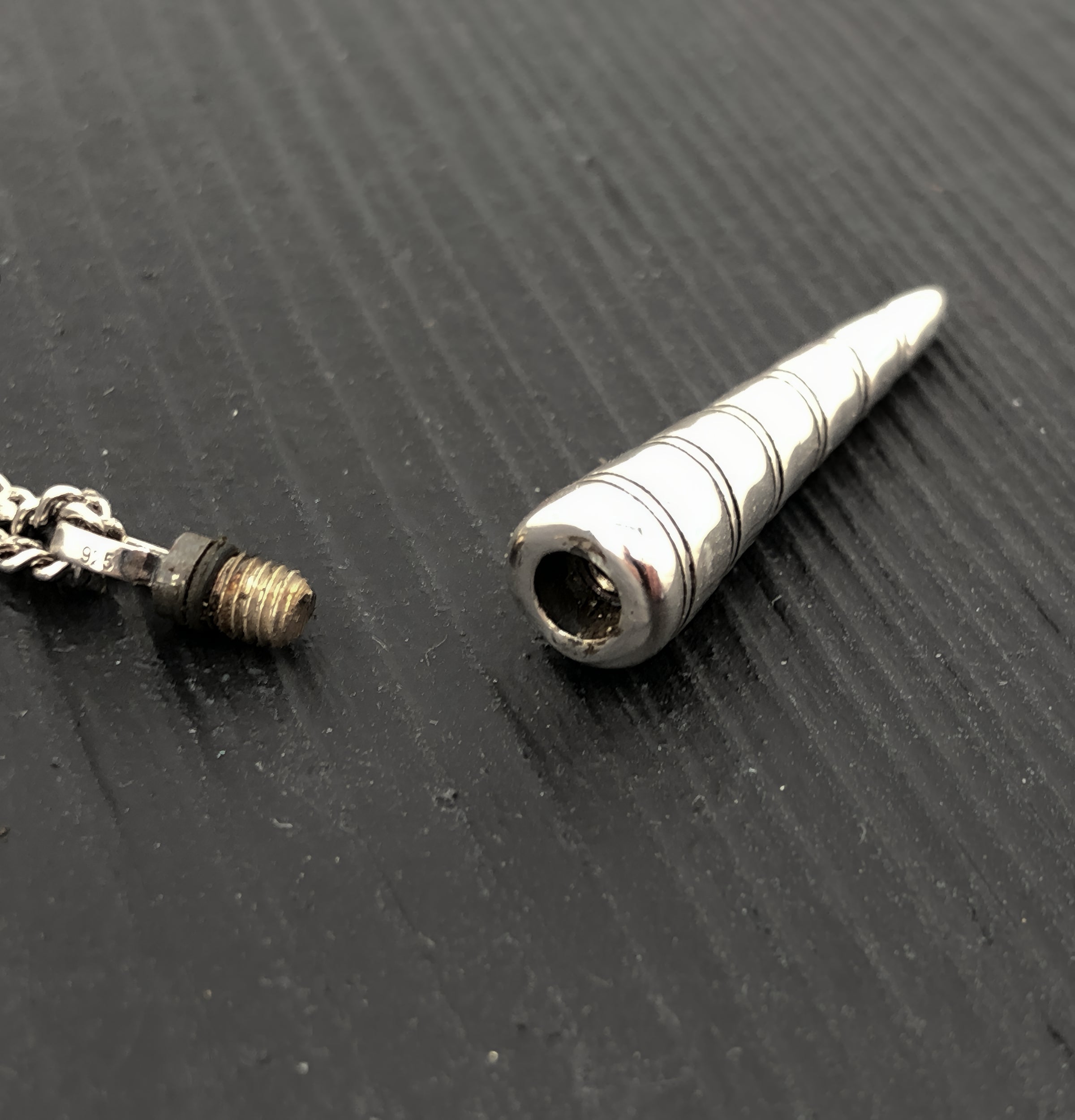 Metallic cylindrical object on a textured black surface