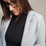 Woman in jacket and glasses, soft smile, neutral background | Moon Raven