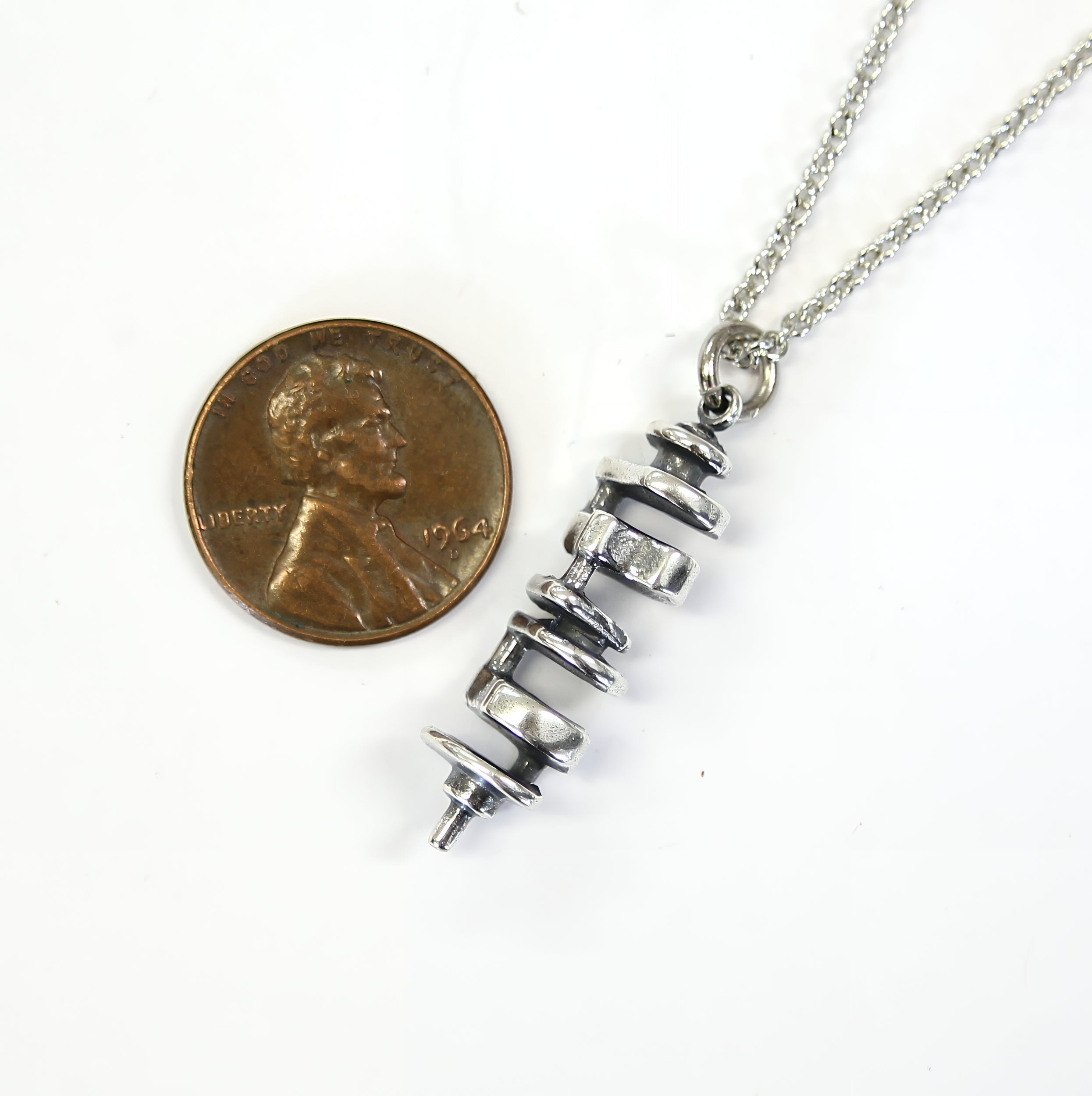 Delicate necklace with small silver coin on top
