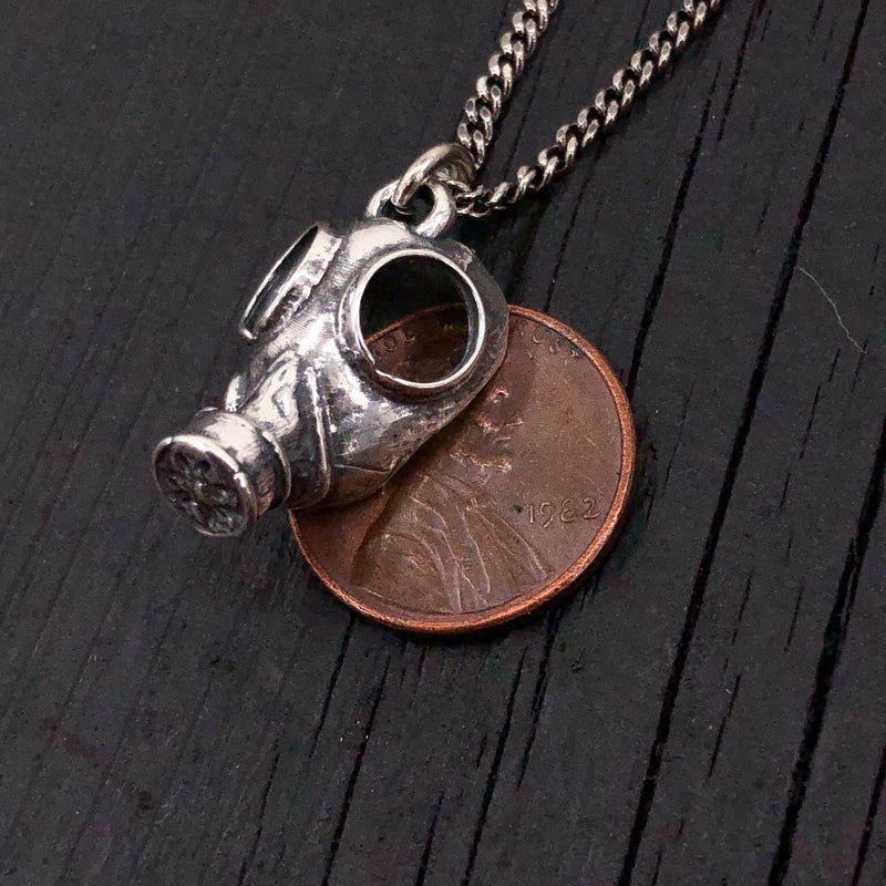 This classic World War 2 era gas mask is scaled down to a mere 3/4&quot; long by 9/16&quot; wide. It is cast in solid sterling silver with a textured oxidized finish that gives it a wonderful post apocalyptic appearance.