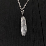 This raven feather is made of solid .925 sterling silver. It is double sided with natural curves that reveal it to be a wing feather. The bail was formed by curling the quill into a circle This lightweight feather measures 1-3/8&quot; long.