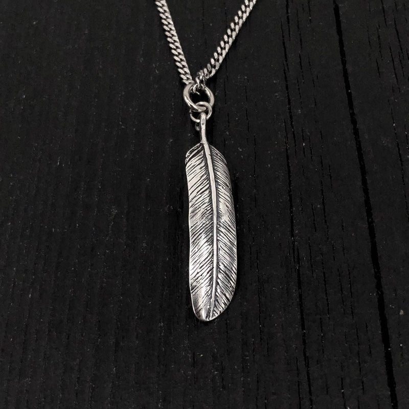 This raven feather is made of solid .925 sterling silver. It is double sided with natural curves that reveal it to be a wing feather. The bail was formed by curling the quill into a circle This lightweight feather measures 1-3/8&quot; long.